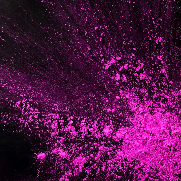Pink dust particles splash against black background