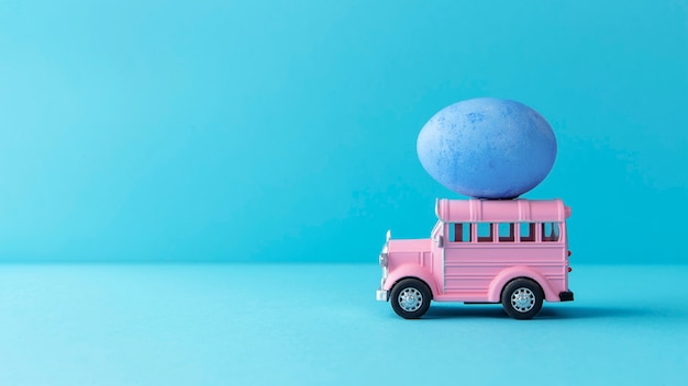 Розовый пасхальный автомобиль с натюрмортом из голубого яйца