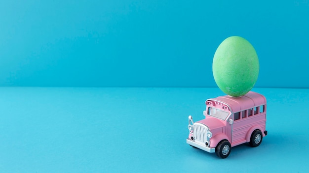 Free photo pink easter car with cute egg still life