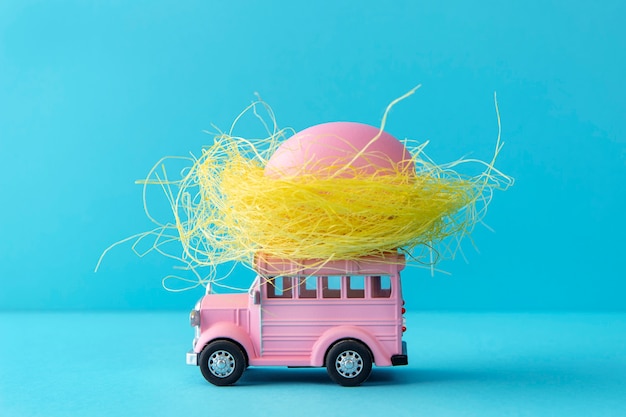 Free photo pink easter car with egg still life