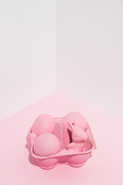 Pink Easter eggs with small rabbit in rack