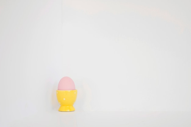 Free photo pink egg in yellow holder