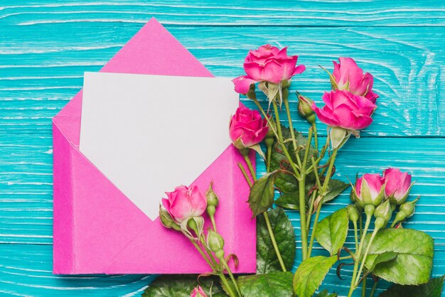 空白のノートと花飾りのついたピンクの封筒