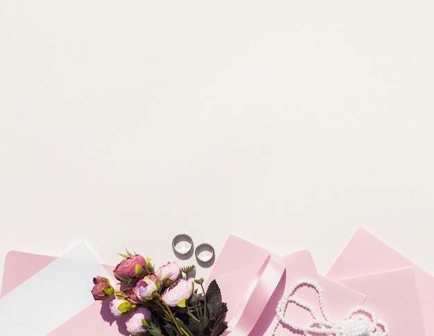 Free photo pink envelopes next to bouquet of roses with copy space
