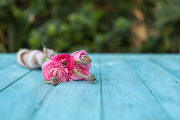 青い木製の厚板上のピンクの花