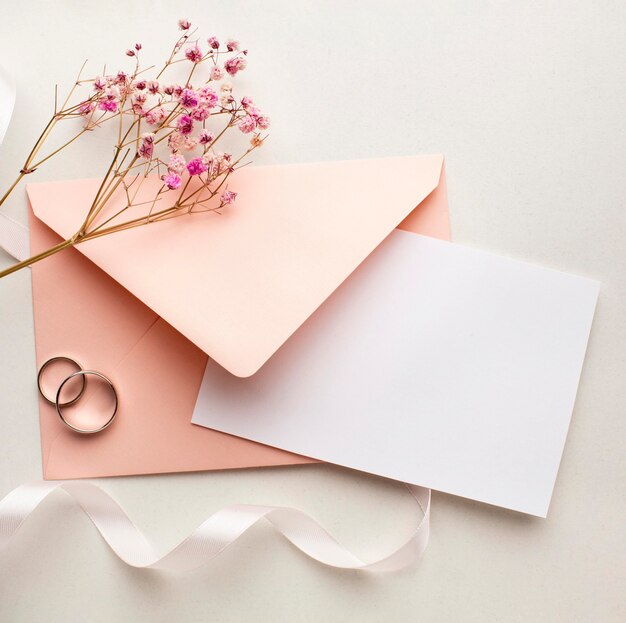 ピンクの花と封筒は日付の結婚式の概念を保存します