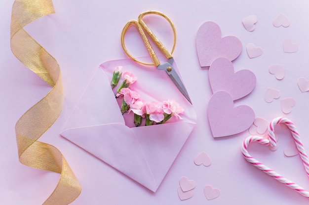 Pink flowers in envelope with paper hearts 