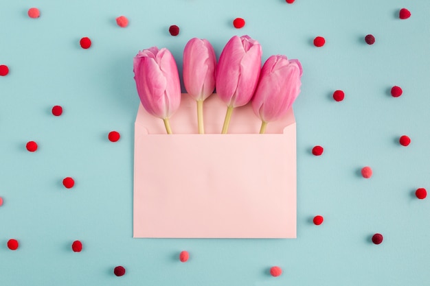 Бесплатное фото Розовые цветы в конверте среди мягких конфетти