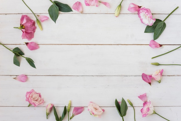 Foto gratuita composizione rosa dei fiori e delle foglie sulla tavola