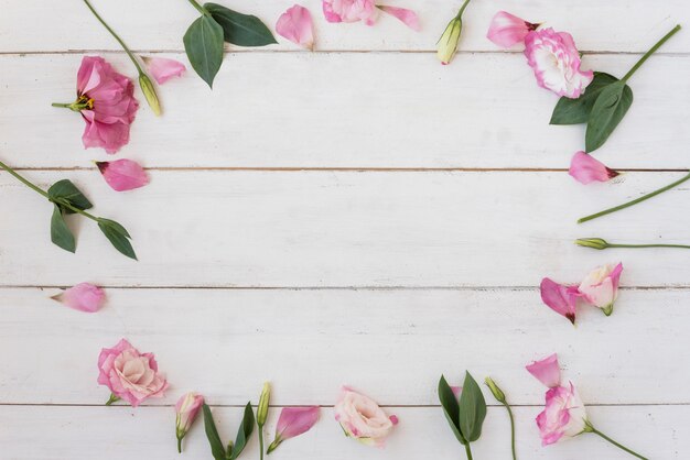 Pink flowers and leaves composition on table