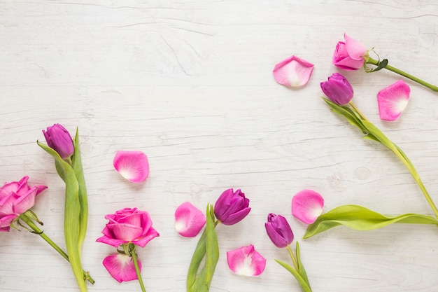 Pink flowers scattered on wooden table