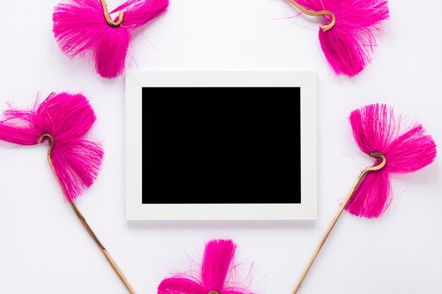 pink flowers with blank frame on white table