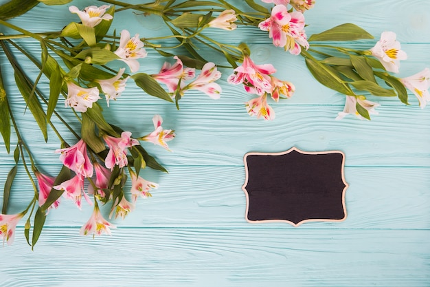 Pink flowers with small chalkboard on table 