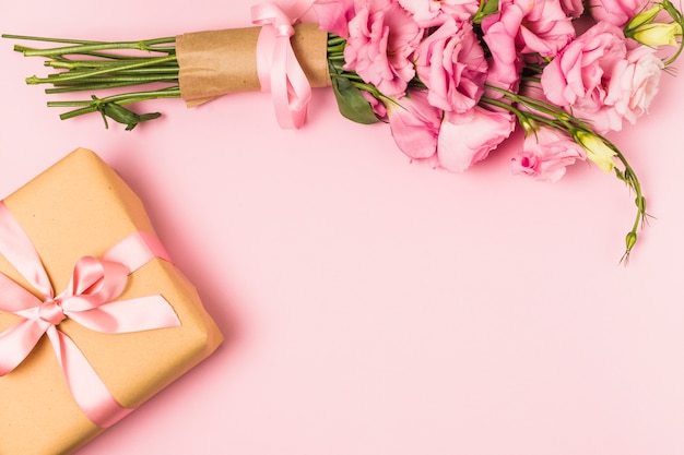 Розовый свежий букет цветов эустомы и подарочная коробка на розовом фоне