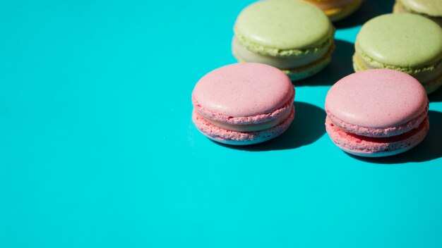 Pink and green macaroons on turquoise backdrop