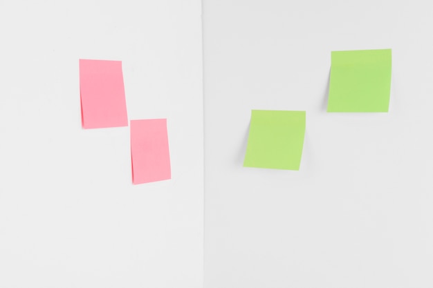 Free photo pink and green sticky notes in corner of room