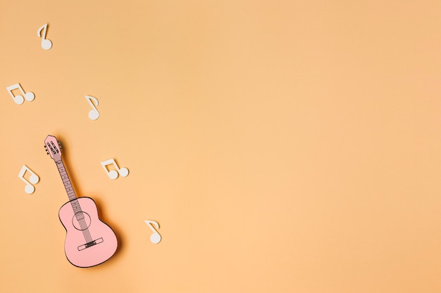 Foto gratuita chitarra rosa con note musicali bianche