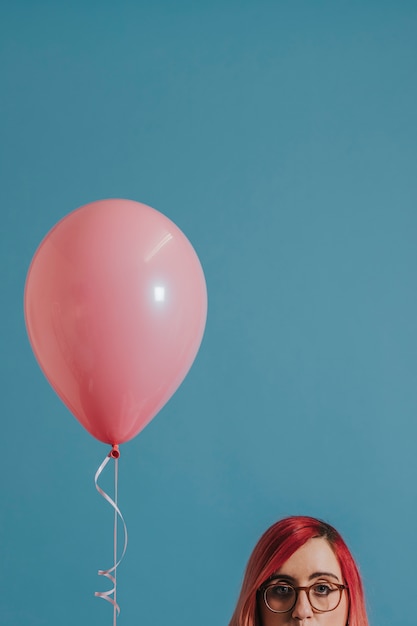 Foto gratuita ragazza dai capelli rosa con un palloncino