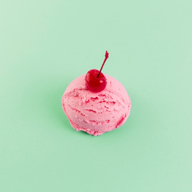 Розовый шарик мороженого с вишней сверху