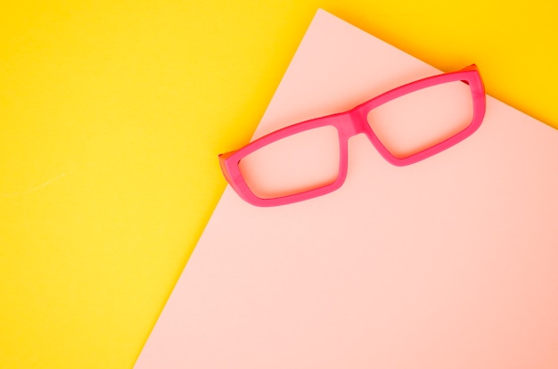 Pink kids eyeglasses on pink and yellow background