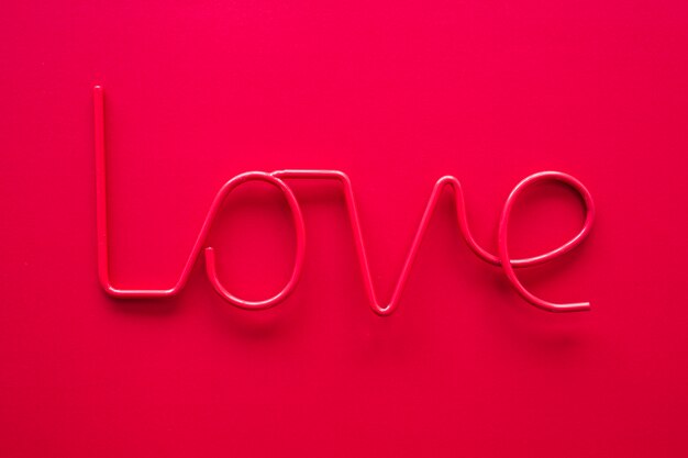 Pink love inscription on red table 