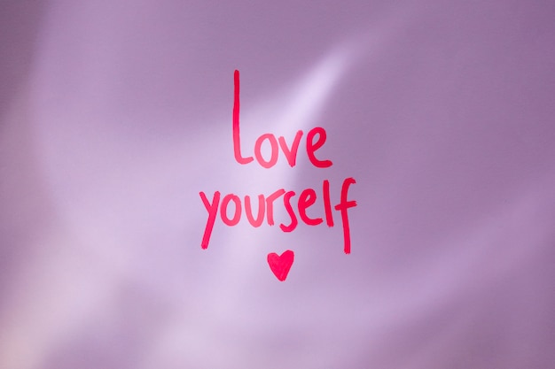 Free photo pink love yourself inscription on table