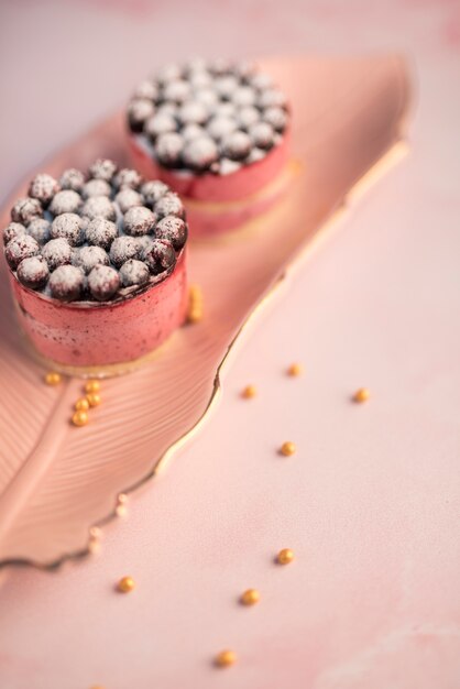 Pink macaroons with flowers on texture backdrop