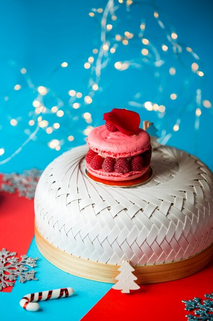 Pink macaroons with raspberries and a leaf of rose