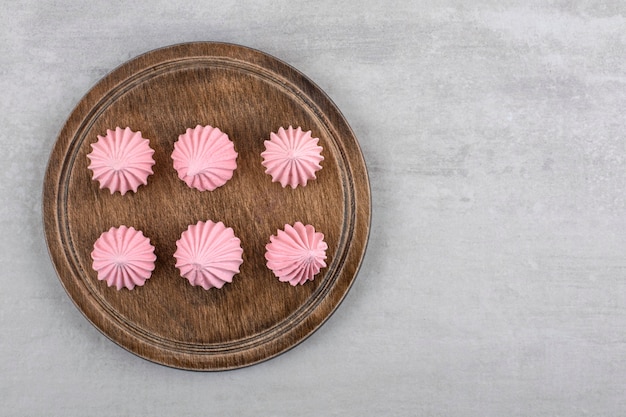 Free photo pink meringue on a board, on the marble table.