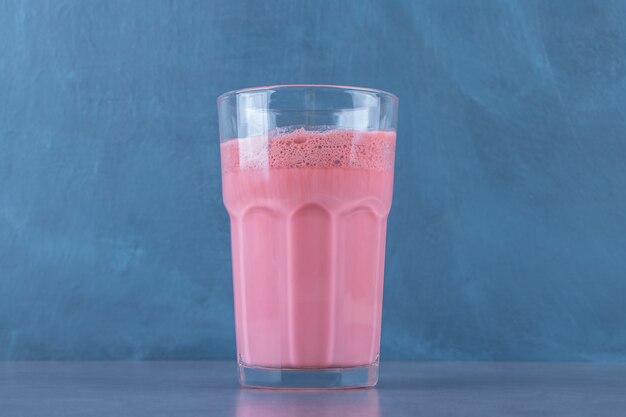 Розовый мокко латте с молоком в стакане на мраморном столе