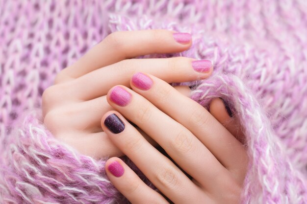 핑크 네일 디자인. 반짝이 매니큐어와 여성의 손입니다.