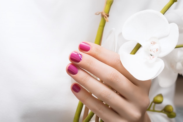 Бесплатное фото Розовый дизайн ногтей. женская рука с блеском маникюра.