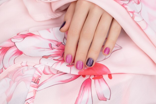 Розовый дизайн ногтей. Женская рука с блеском маникюра.