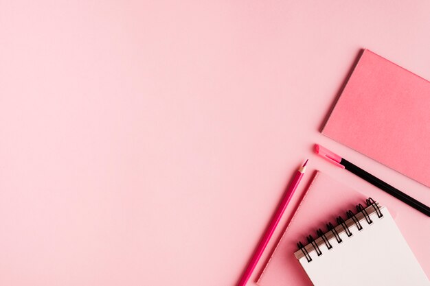 Pink office supplies on colored surface