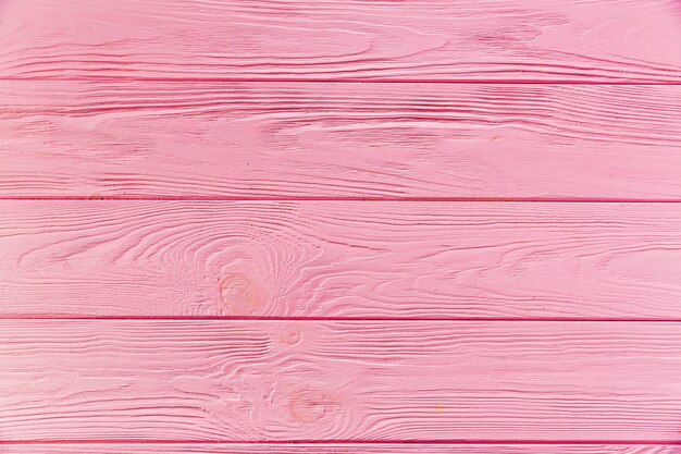 Pink painted rough wooden surface