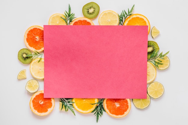 Free photo pink paper of delicious sliced fruits