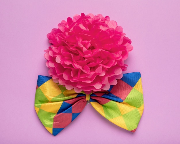 Бесплатное фото Розовый бумажный цветок и красочный галстук-бабочка