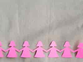Free photo pink paper girl holding hands cutout