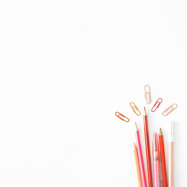 Free photo pink pencils and clips on white table