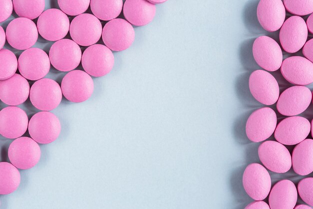 Pink pills on isolated backdrop