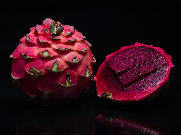 Pink pitaya passion fruit isolated on a black background