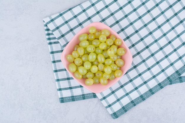 Free photo a pink plate full of green delicious grapes. high quality photo