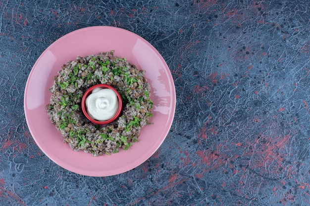 Free photo a pink plate of mincemeat with peas and herbs .