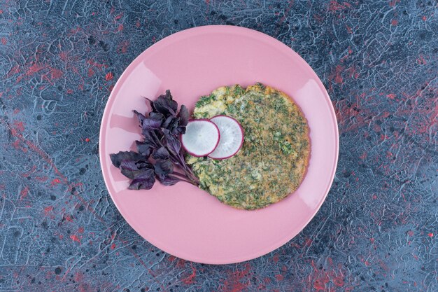 A pink plate of mincemeat with peas and herbs 