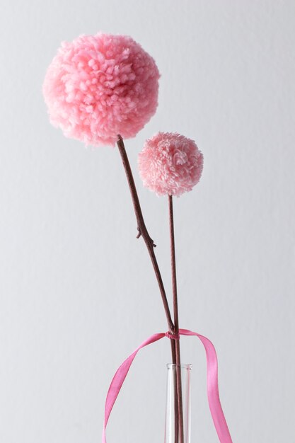 Pink pom poms in vase with white background