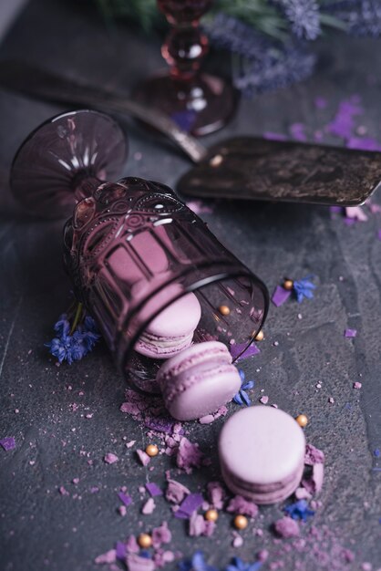 Pink and purple creamy eclairs on black slate textured backdrop