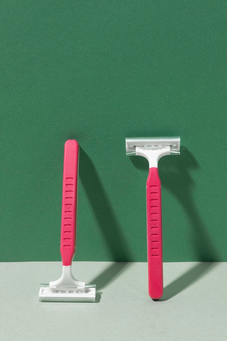 Free Photo pink razor blades leaning on a wall