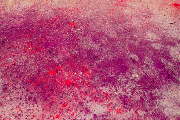 Pink and red holi color splatter on the ground