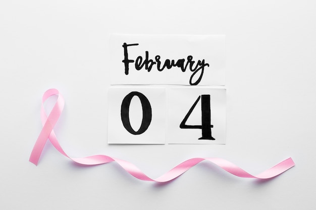 Free photo pink ribbon under february 4 writing