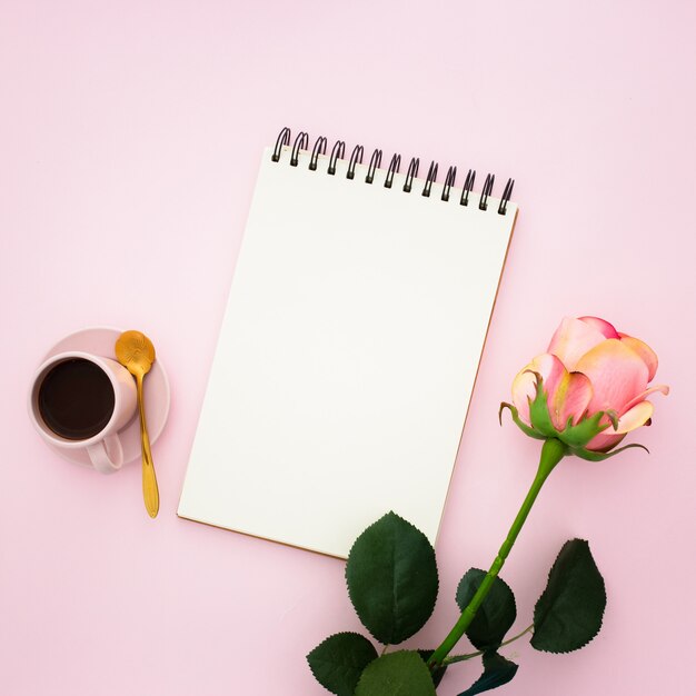 Pink rose, coffee and notebook 